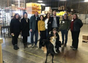 The Ship Sunshine staff of nine and their two dogs pose inside their warehouse.